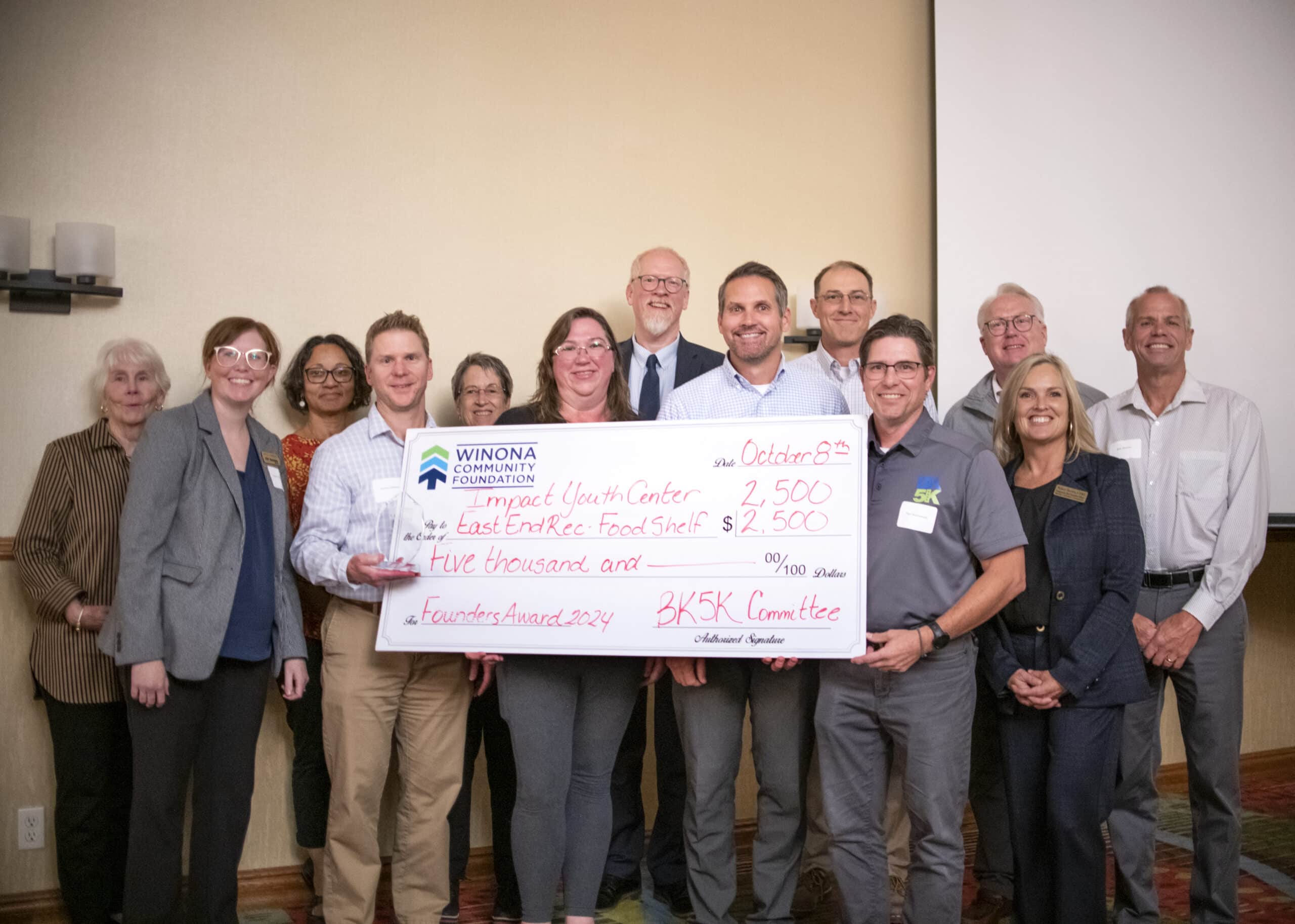 foundation board and award recipients stand with large grant check